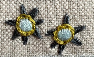 An example of how the smaller stars were sewn with grey Fly stitch points, pale blue Satin stitch centres, edged with yellow chain or split stitches